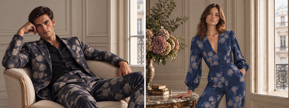 A man in a printed Lords of Harlech suit and a woman in a blue floral dress in an elegant paneled interior