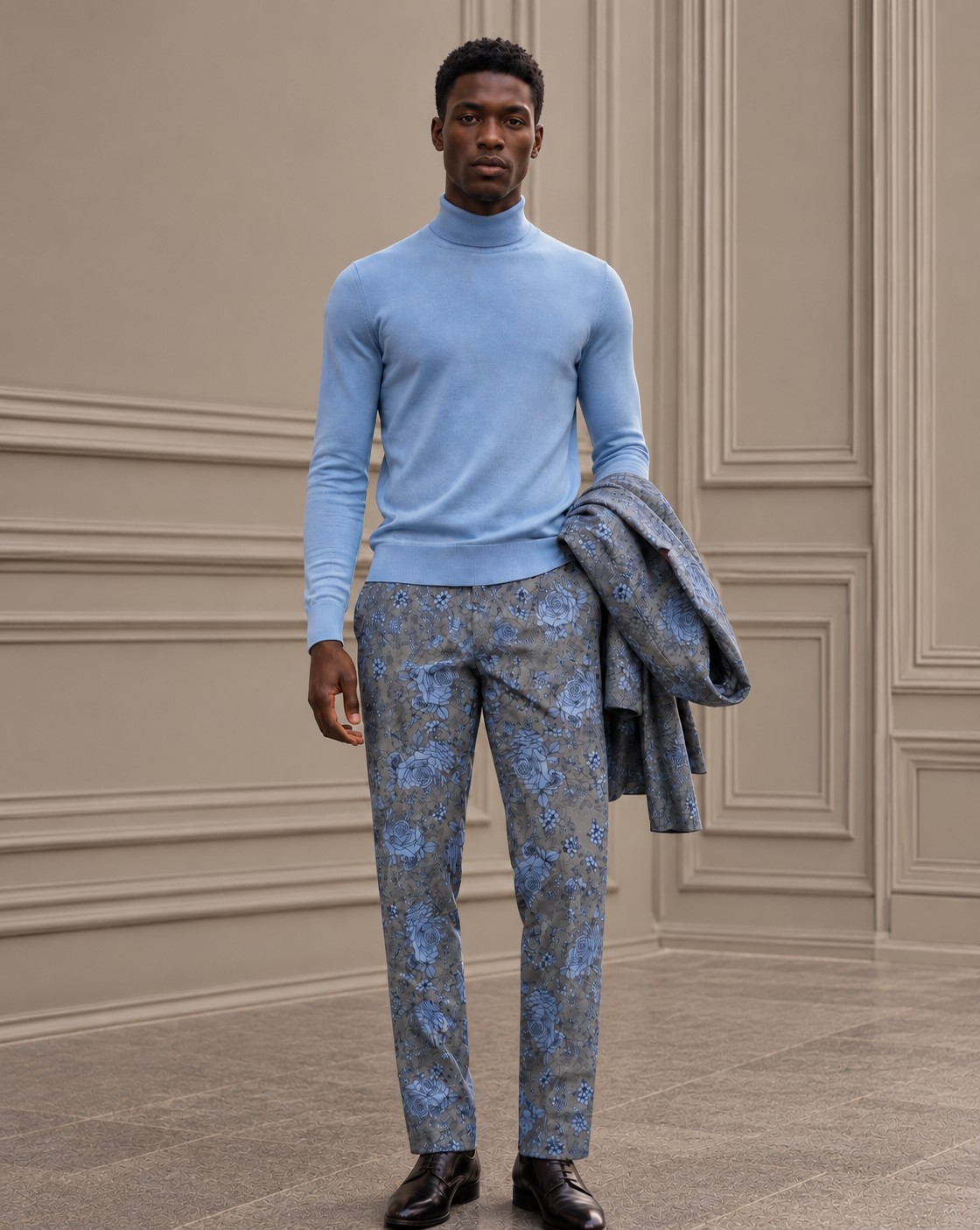 A man in the Lords of Harlech Uomo Ronan turtleneck in sky with Paxton pant in Roma Floral, holding the matching Judd blazer
